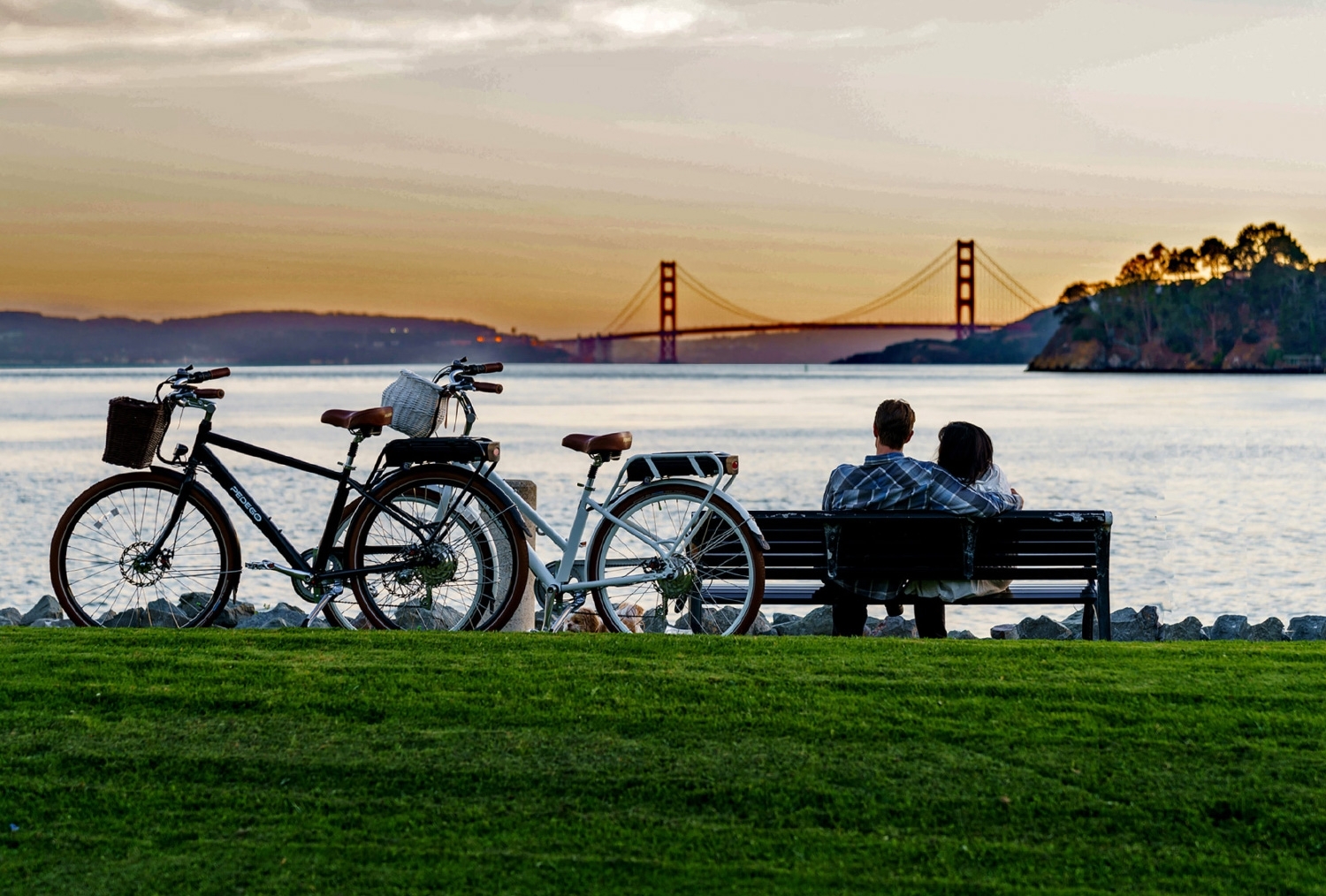 Couple sitting on a bench with bicycles behind them at Shoreline Park watching the sunset over the Golden Gate Bridge9-5956.jpg